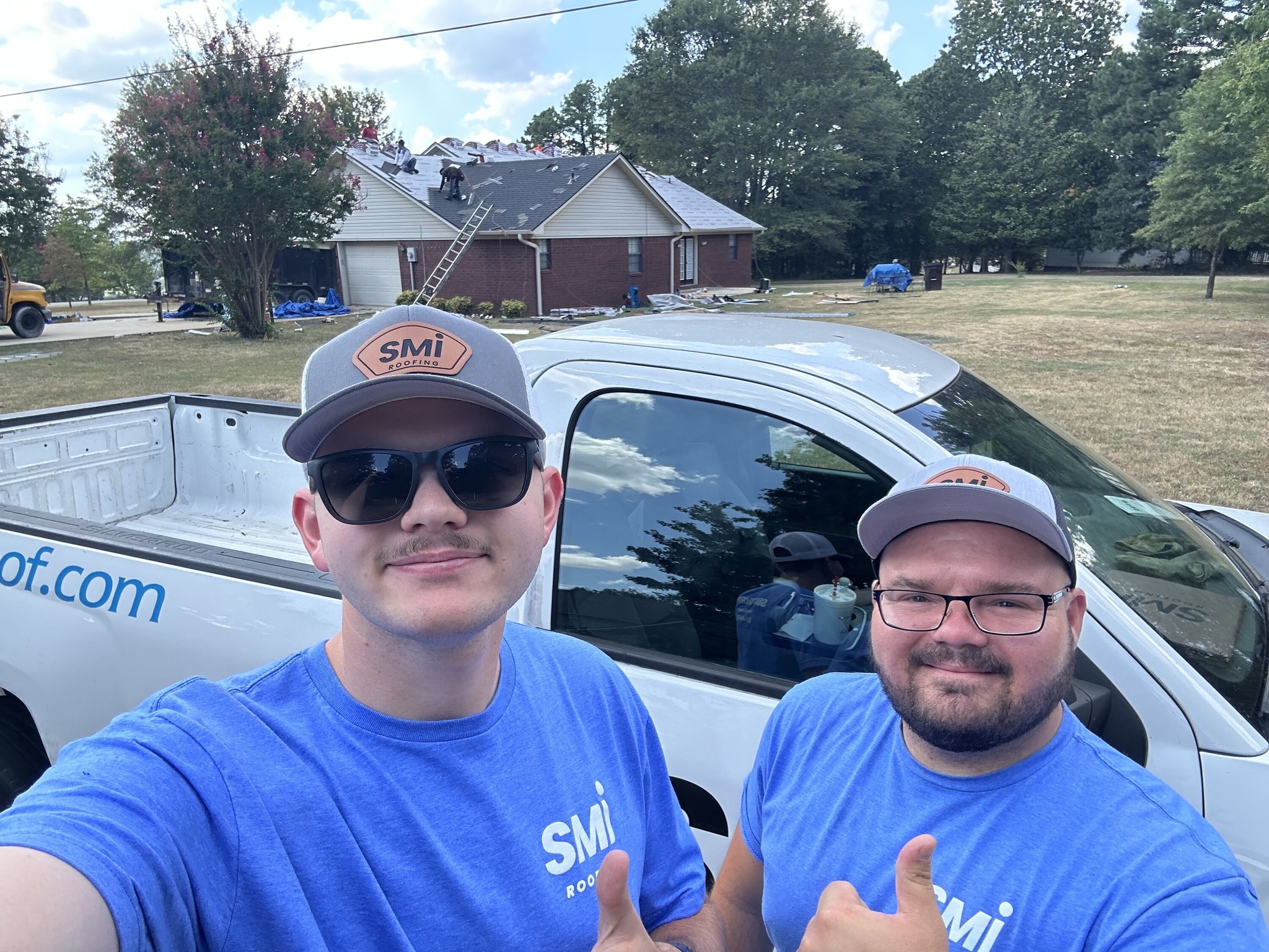 Two SMI Roofing team members at an active Arkansas roof replacement jobsite